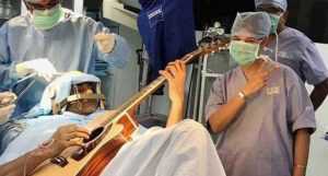 toca violão em sua própria cirurgia