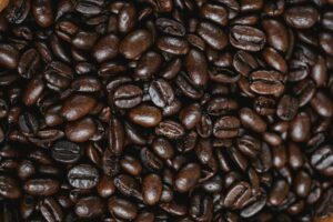 Grãos de café torrados em close-up, mostrando textura e cores acastanhadas