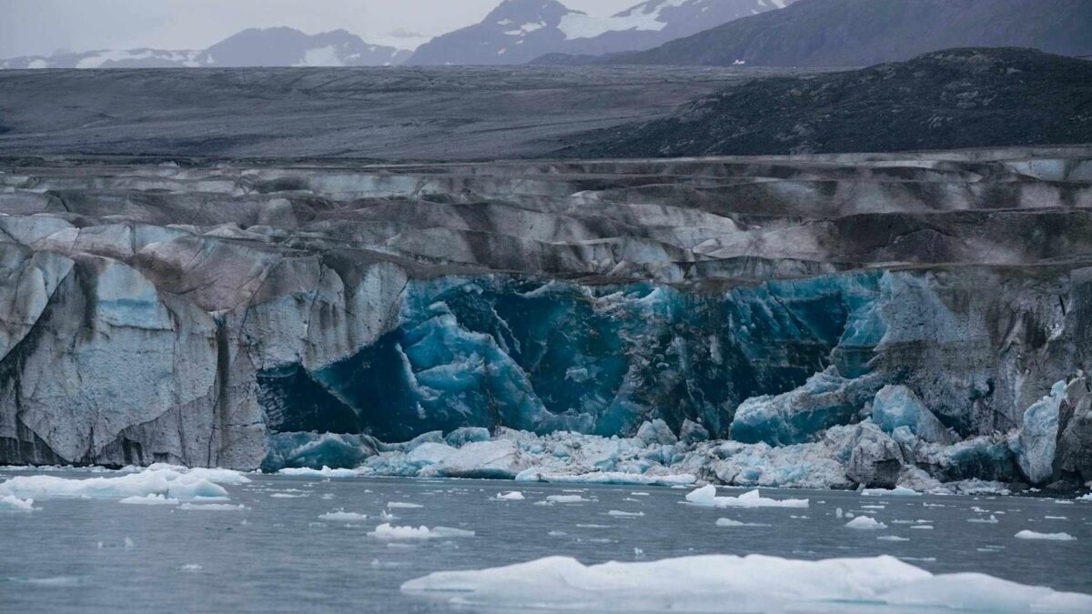 Glaciar derretendo em região polar com águas azuis do oceano, liberando sedimentos ricos em ferro