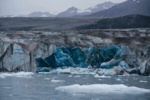 Glaciar derretendo em região polar com águas azuis do oceano, liberando sedimentos ricos em ferro