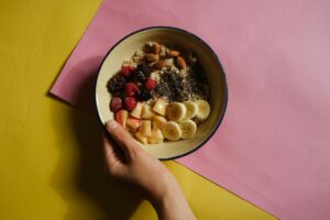 Alimentos ricos em fibra incluindo frutas vermelhas congeladas, macarrão integral e sementes de chia dispostos em superfície clara